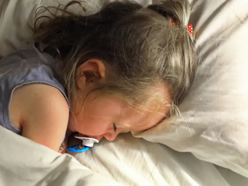 melatonin for kids guide - Young child sleeping in bed (Fieldnotes)