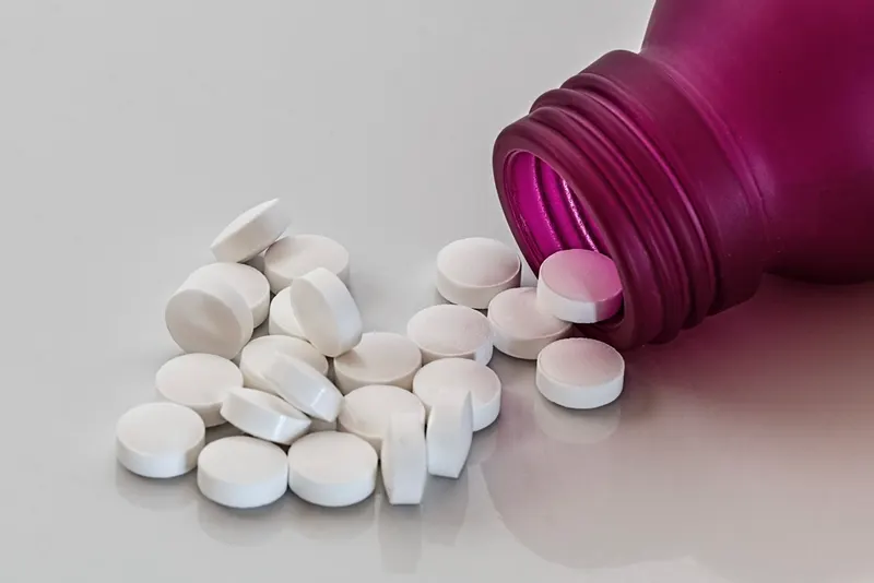 melatonin supplements sleep guide - White tablets spilling from a supplement bottle (Fieldnotes)